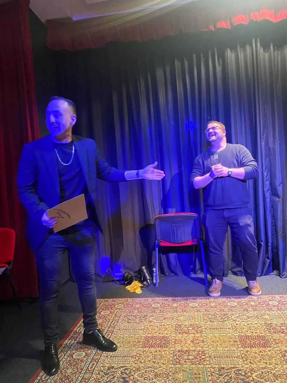 Larry en escena junto a un voluntario, bajo luz azul
