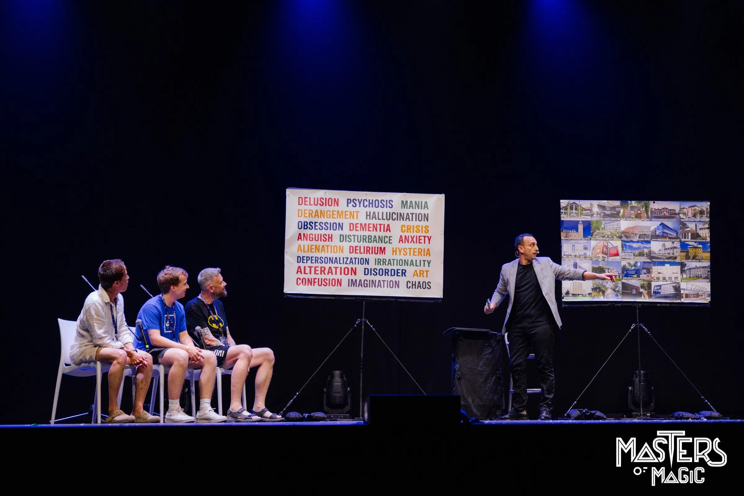 Larry en escena con tres voluntarios sentados y una pizarra de palabras
